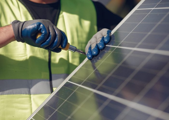 Engineer in a white helmet. Man near solar panel.
